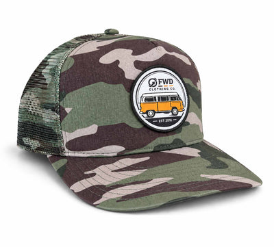 An army camouflage trucker hat from FWD Clothing with green, brown, and beige camo pattern on the front and visor, and a green mesh back. It features a circular embroidered patch on the front with a yellow-orange vintage van and the text 'FWD CLOTHING CO.
